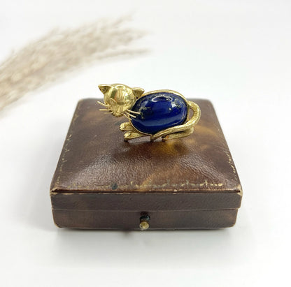 A yellow gold cat brooch with a lapis lazuli body