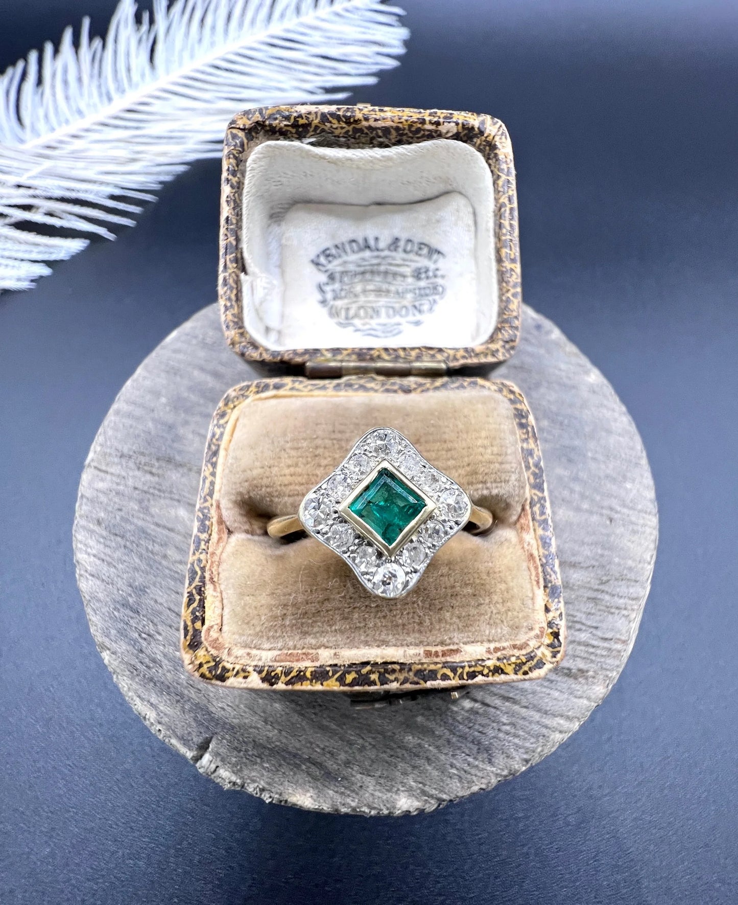 An emerald and diamond cluster ring in yellow gold and platinum, in an antique ring box