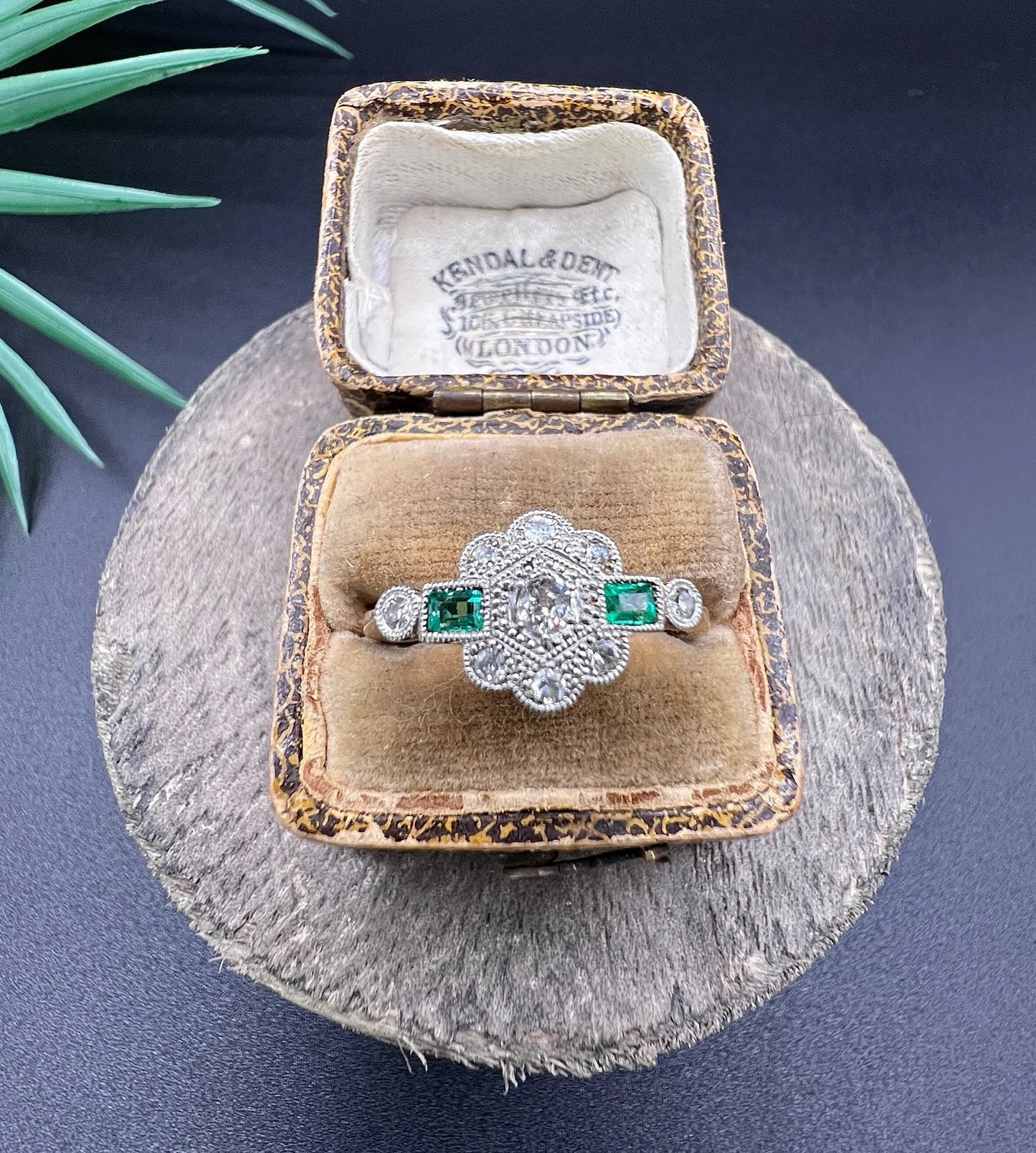 An emerald and diamond floral cluster ring in yellow gold and platinum, in an antique ring box