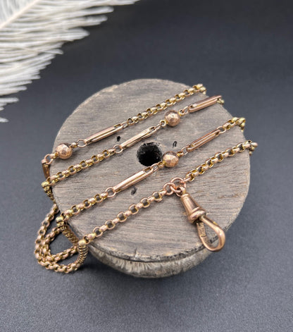 A long rose gold chain necklace with a dog clip clasp
