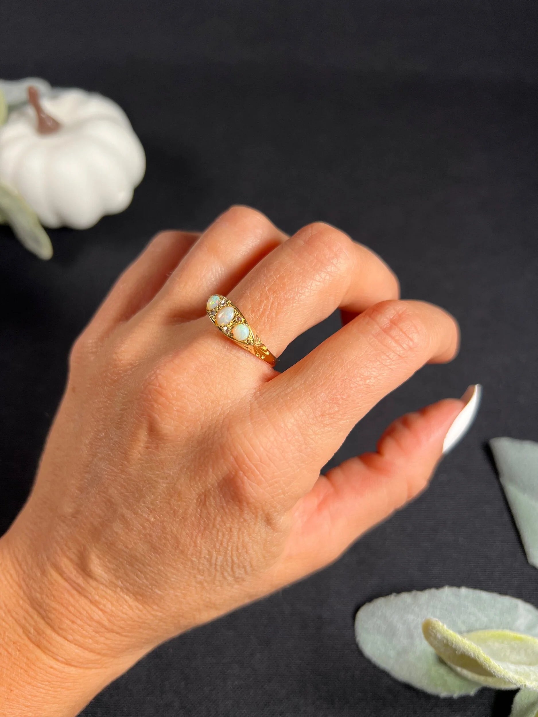 A boat-shaped gold ring with opals and diamonds, modelled on a hand