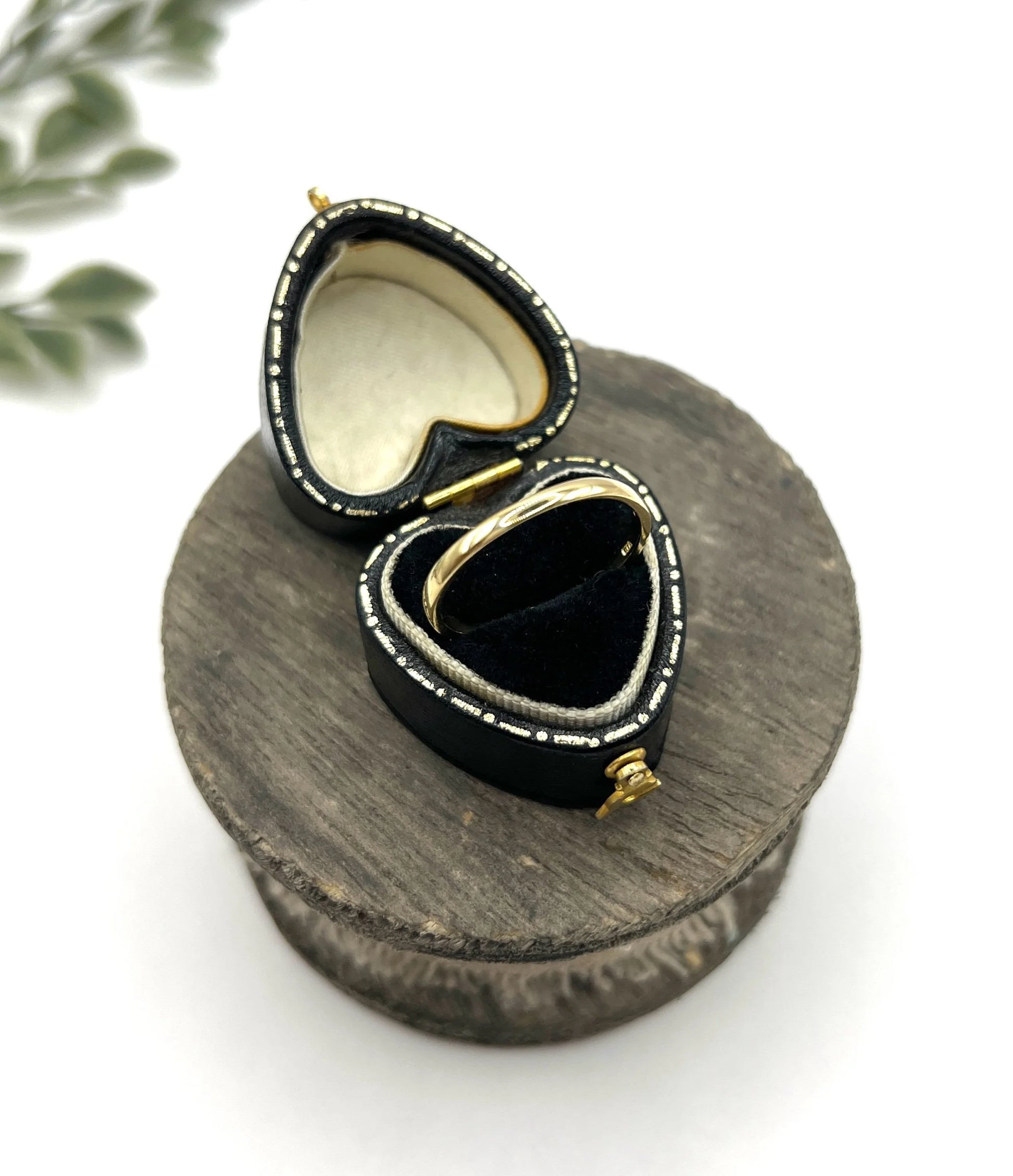 A yellow gold ring in a heart-shaped ring box