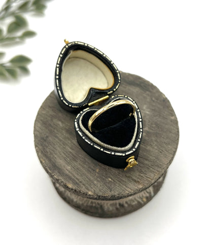 A yellow gold ring in a heart-shaped ring box