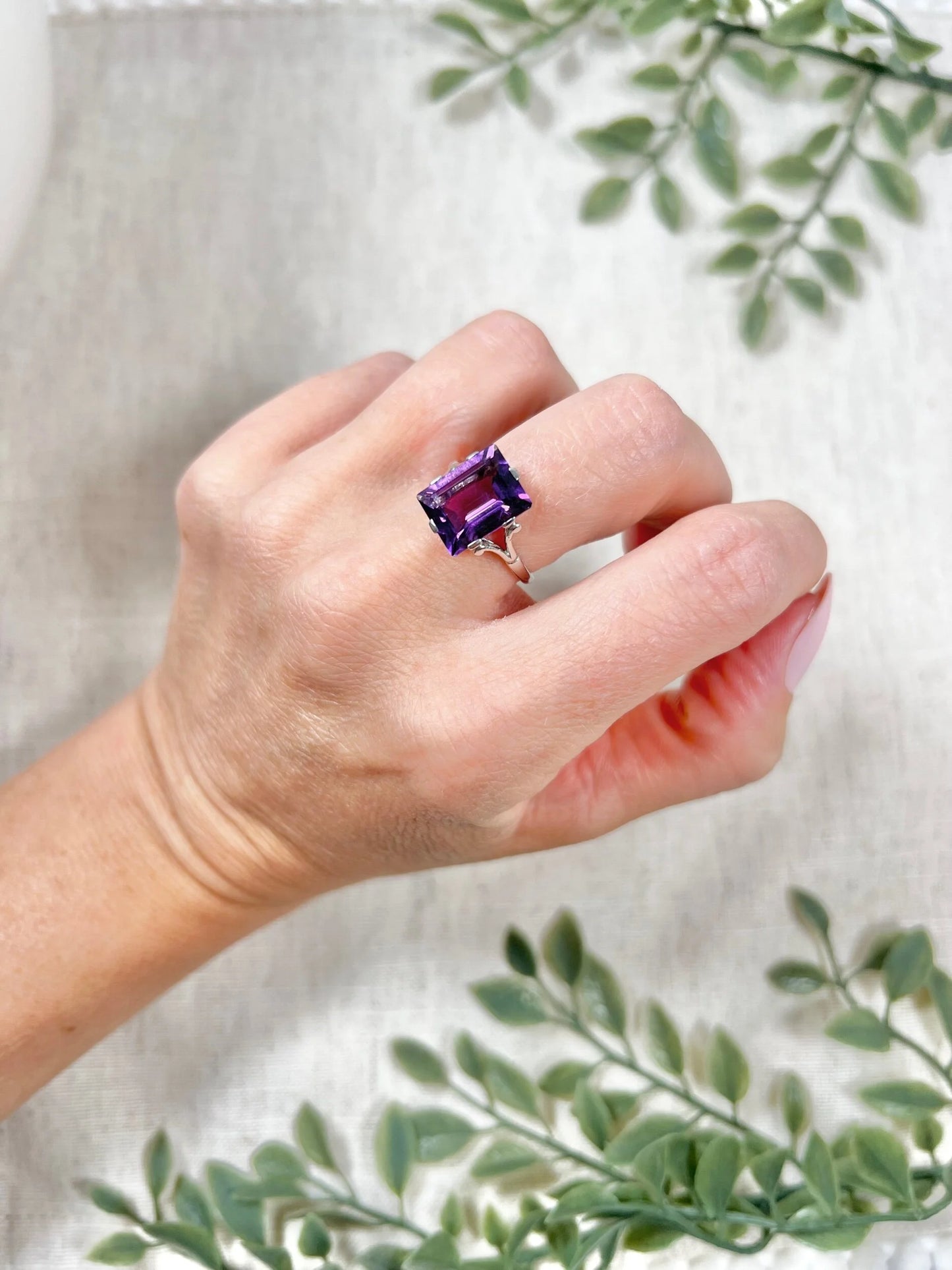 A solitaire amethyst cocktail ring in platinum, modelled on a hand