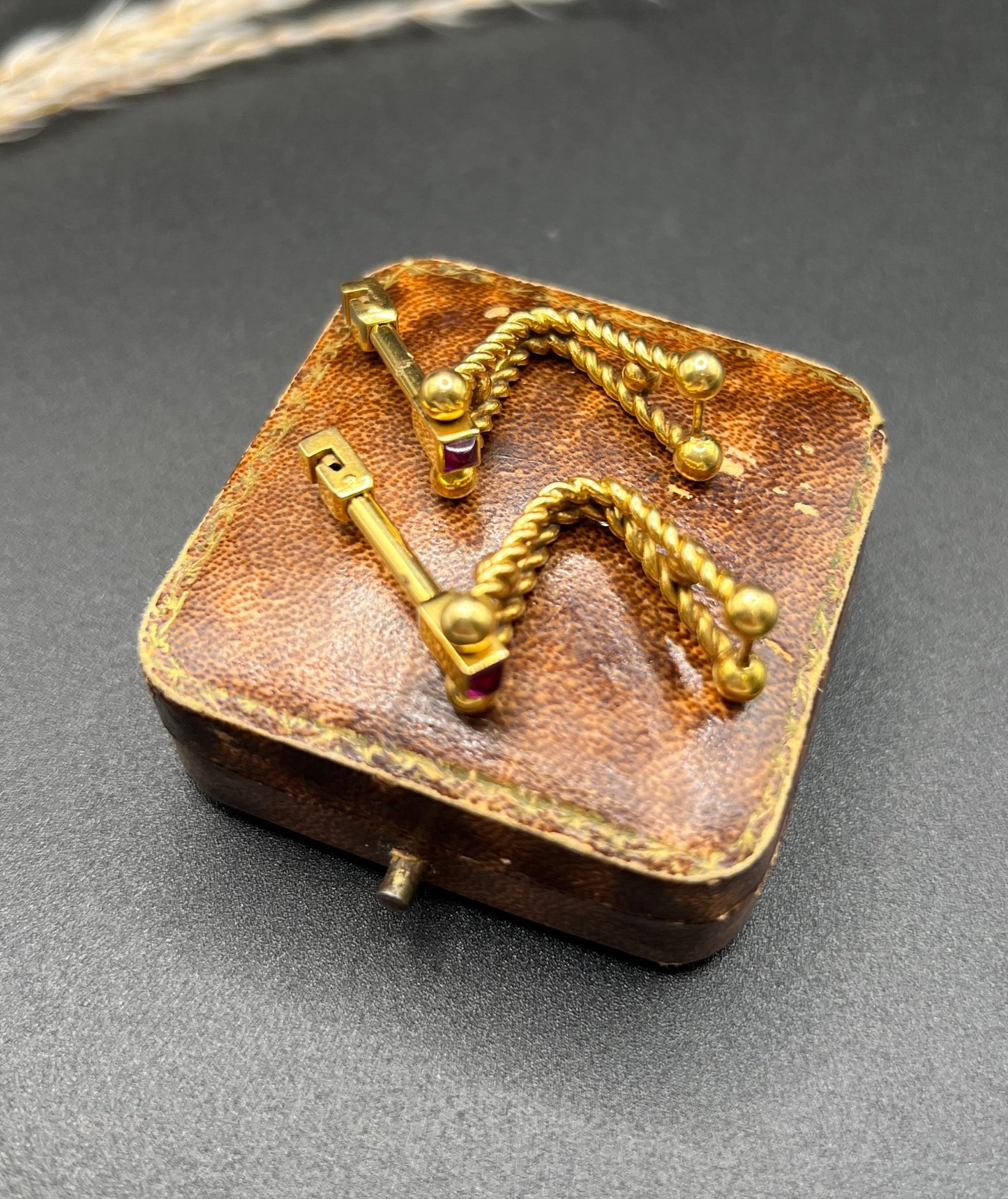 A pair of yellow gold ruby cufflinks, on an antique box