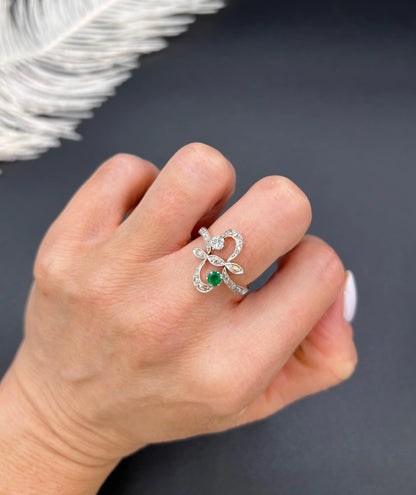An emerald and diamond fancy openwork ring in yellow gold and platinum, modelled on a hand