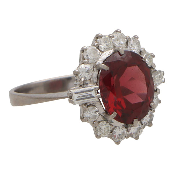 Garnet and diamond halo ring set in platinum.