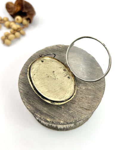 An antique oval silver locket