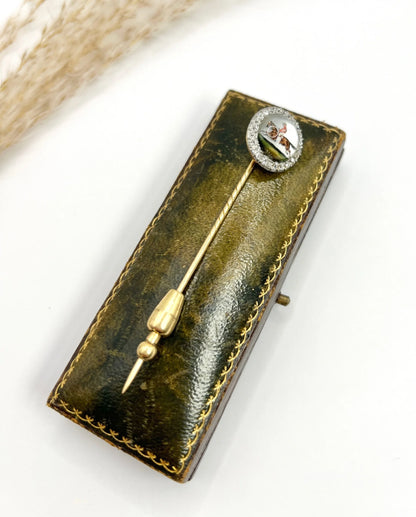 An antique Essex glass and diamond stick pin depicting a jockey riding a horse, on a box