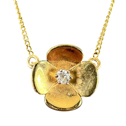A yellow gold and diamond flower pendant necklace, on a white background