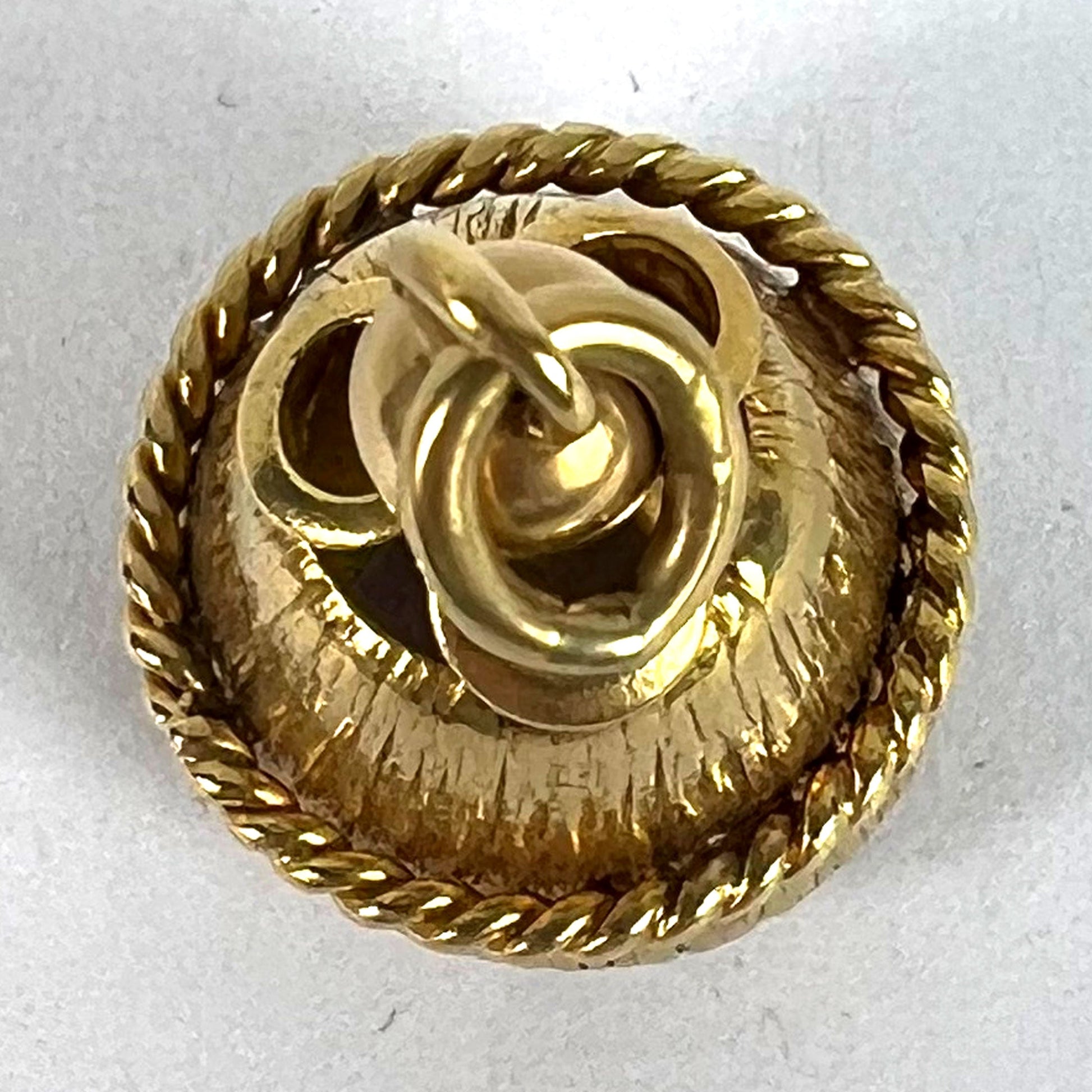A yellow gold pendant, on a white background