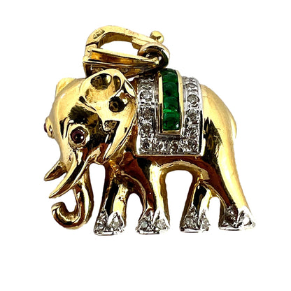 A yellow gold elephant pendant with rubies, emeralds and diamonds, on a white background