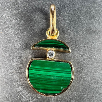 A malachite and diamond yellow gold split circle pendant, on a grey background
