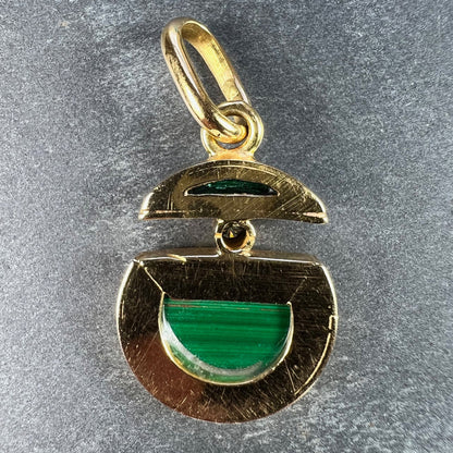 A malachite and diamond yellow gold split circle pendant, on a grey background