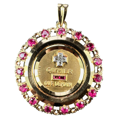 A French QU'HIER QUE DEMAIN pendant with diamonds and synthetic rubies, on a white background