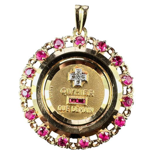 A French QU'HIER QUE DEMAIN pendant with diamonds and synthetic rubies, on a white background