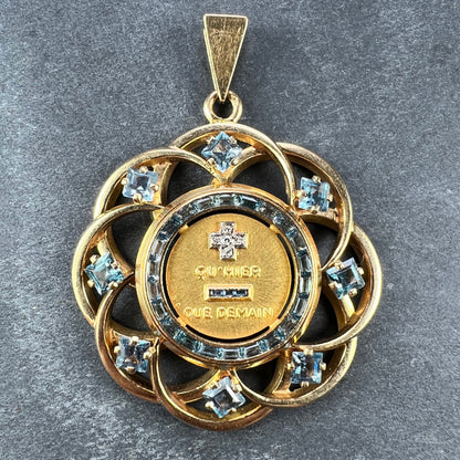 A yellow gold French QU'HIER QUE DEMAIN pendant with blue stones and diamonds, on a grey background