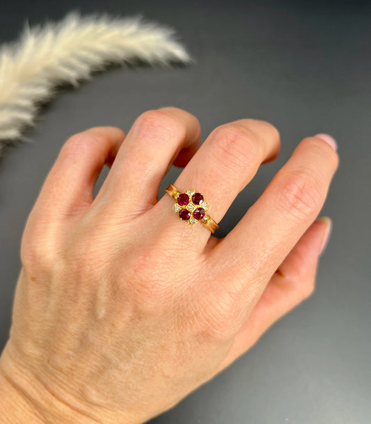 A ruby and diamond cross design ring in yellow gold, modelled on a hand