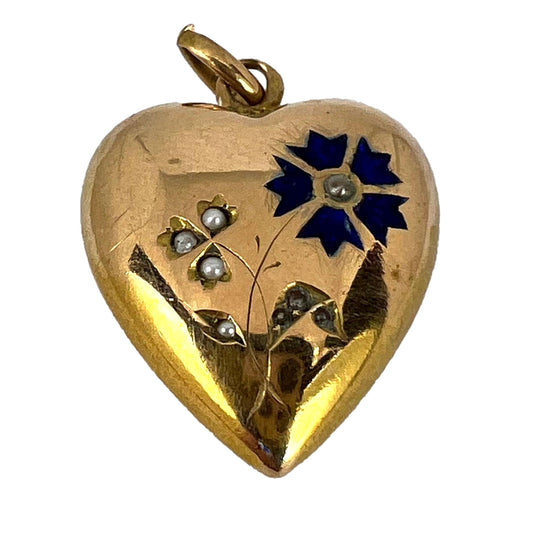 A yellow gold heart shaped pendant with enamel and seed pearls, on a white background
