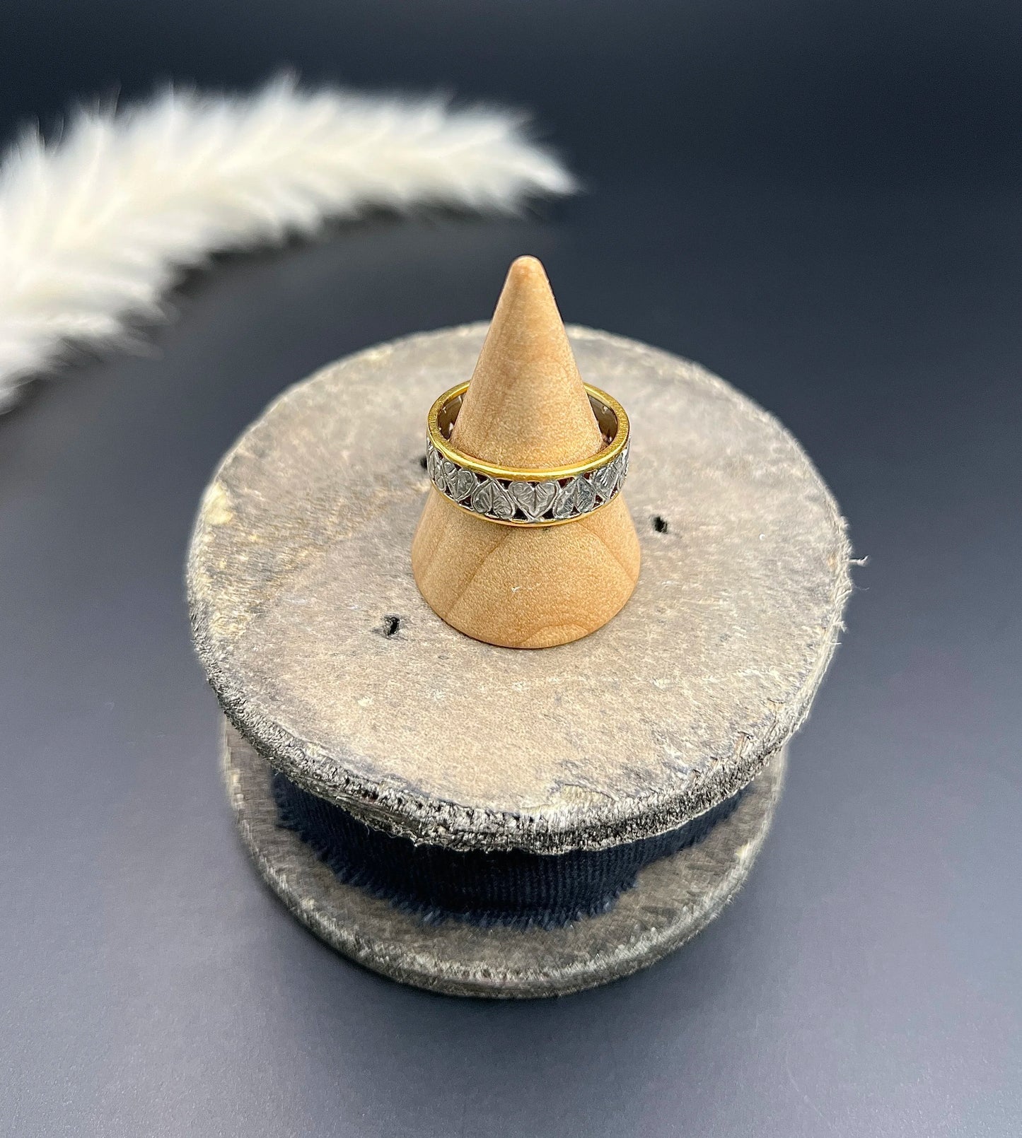 A yellow gold and platinum heart cutout band ring, on a ring cone