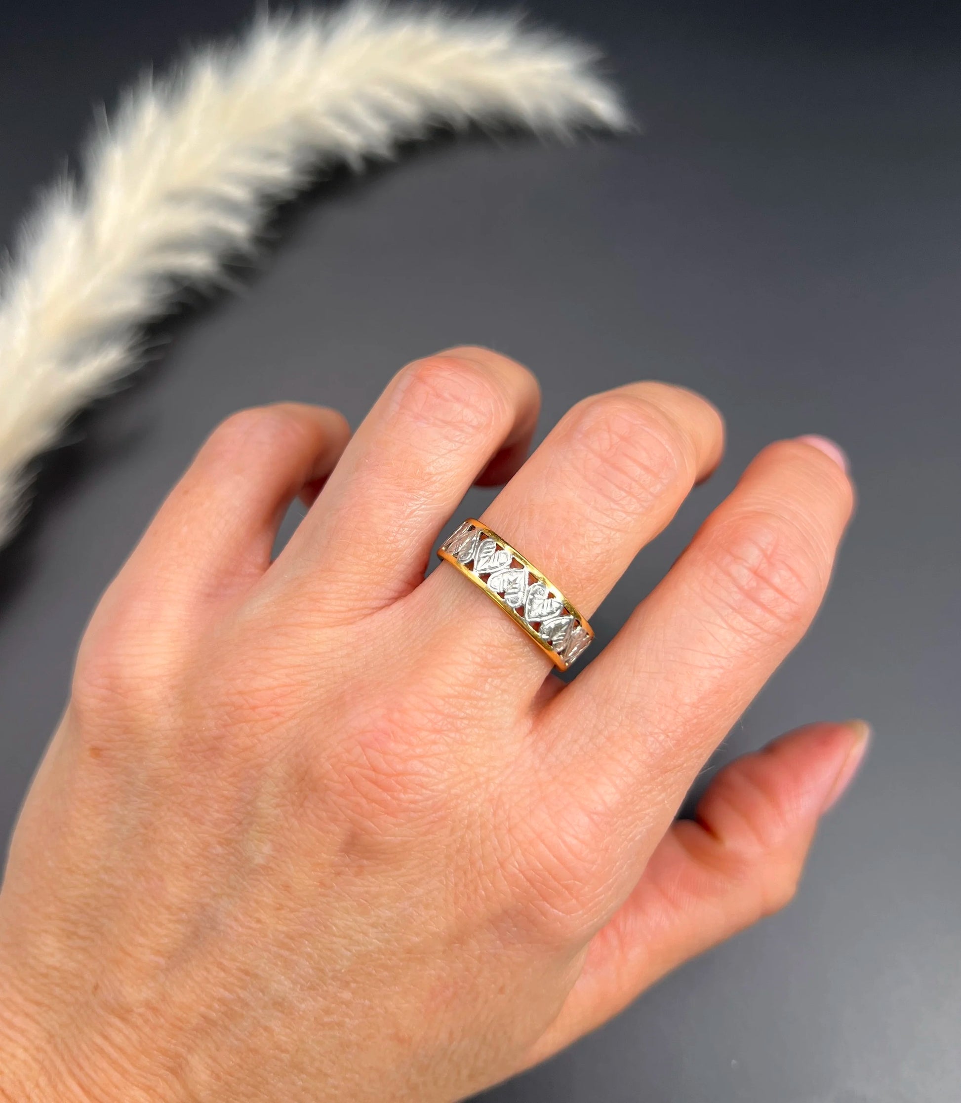 A yellow gold and platinum heart cutout band ring, modelled on a hand