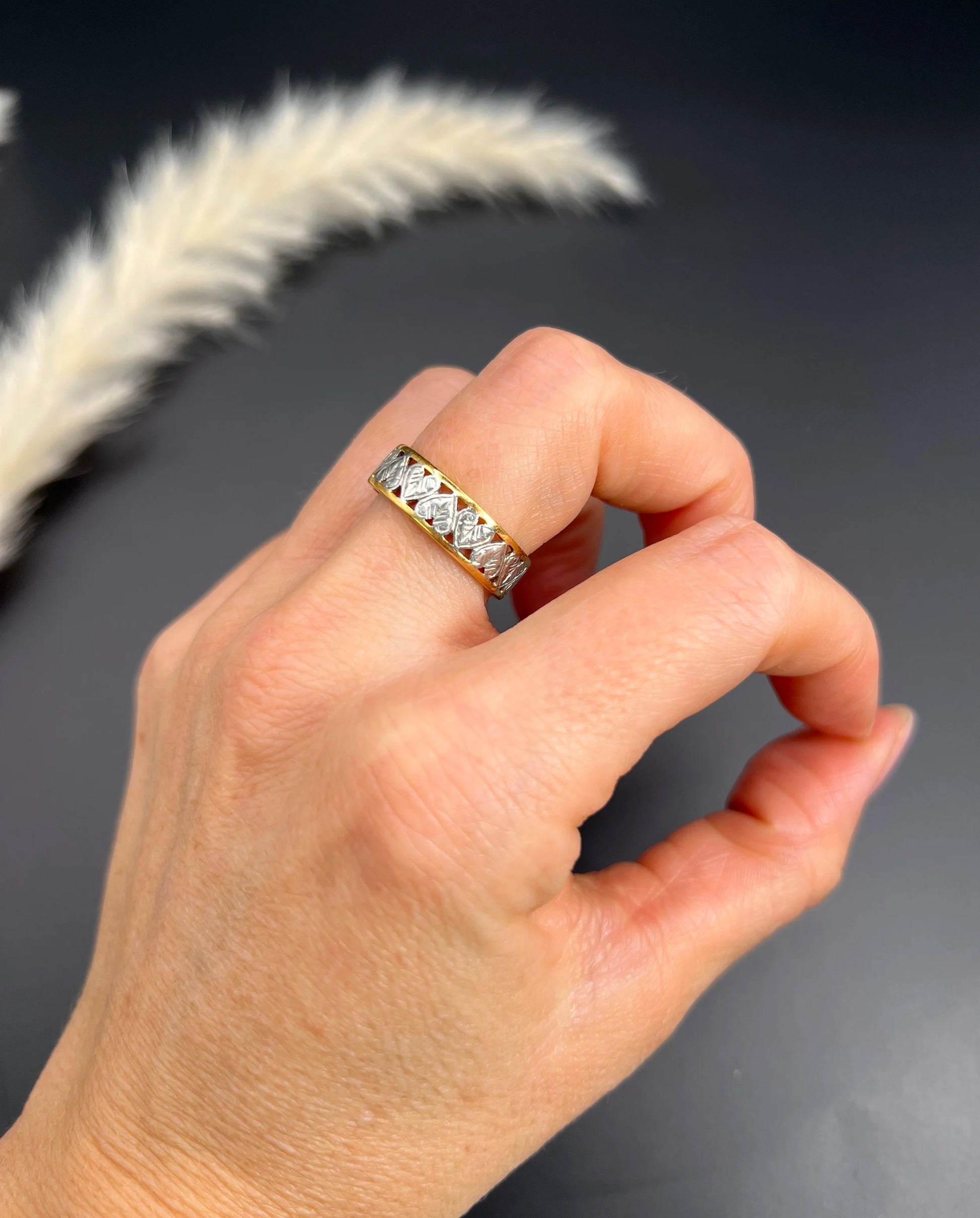 A yellow gold and platinum heart cutout band ring, modelled on a hand