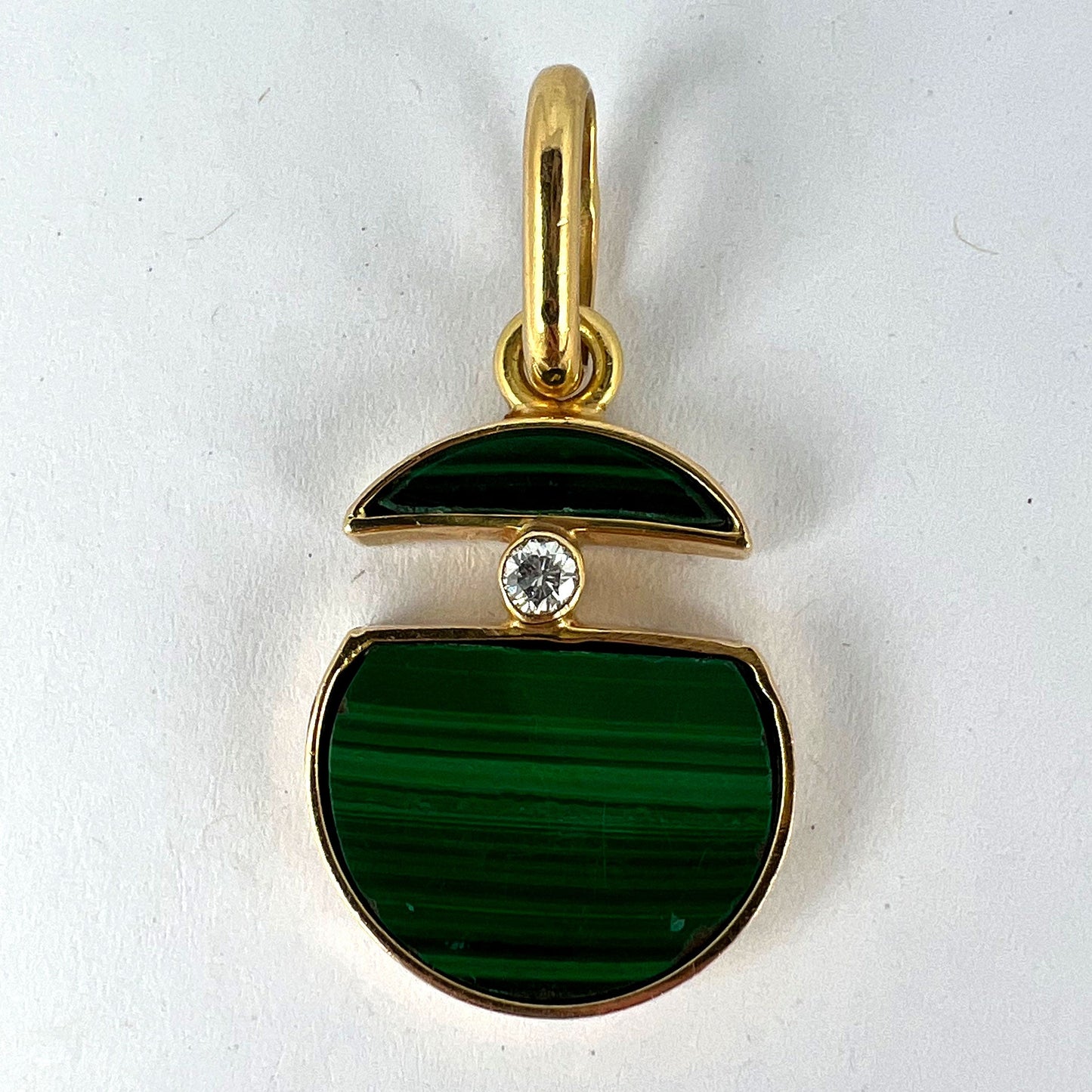 A malachite and diamond yellow gold split circle pendant, on a white background