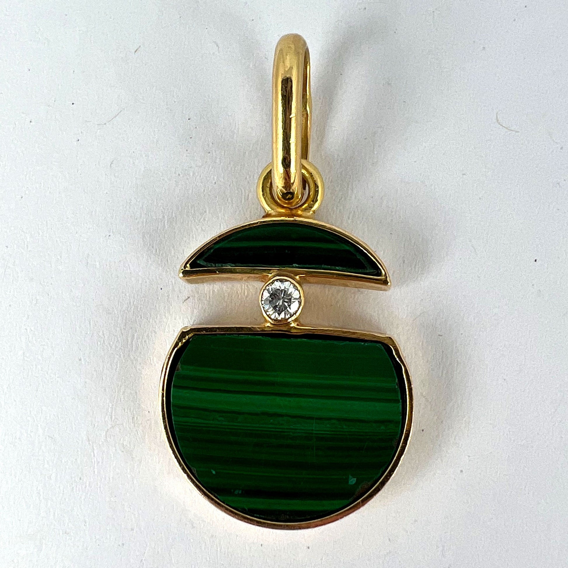 A malachite and diamond yellow gold split circle pendant, on a white background