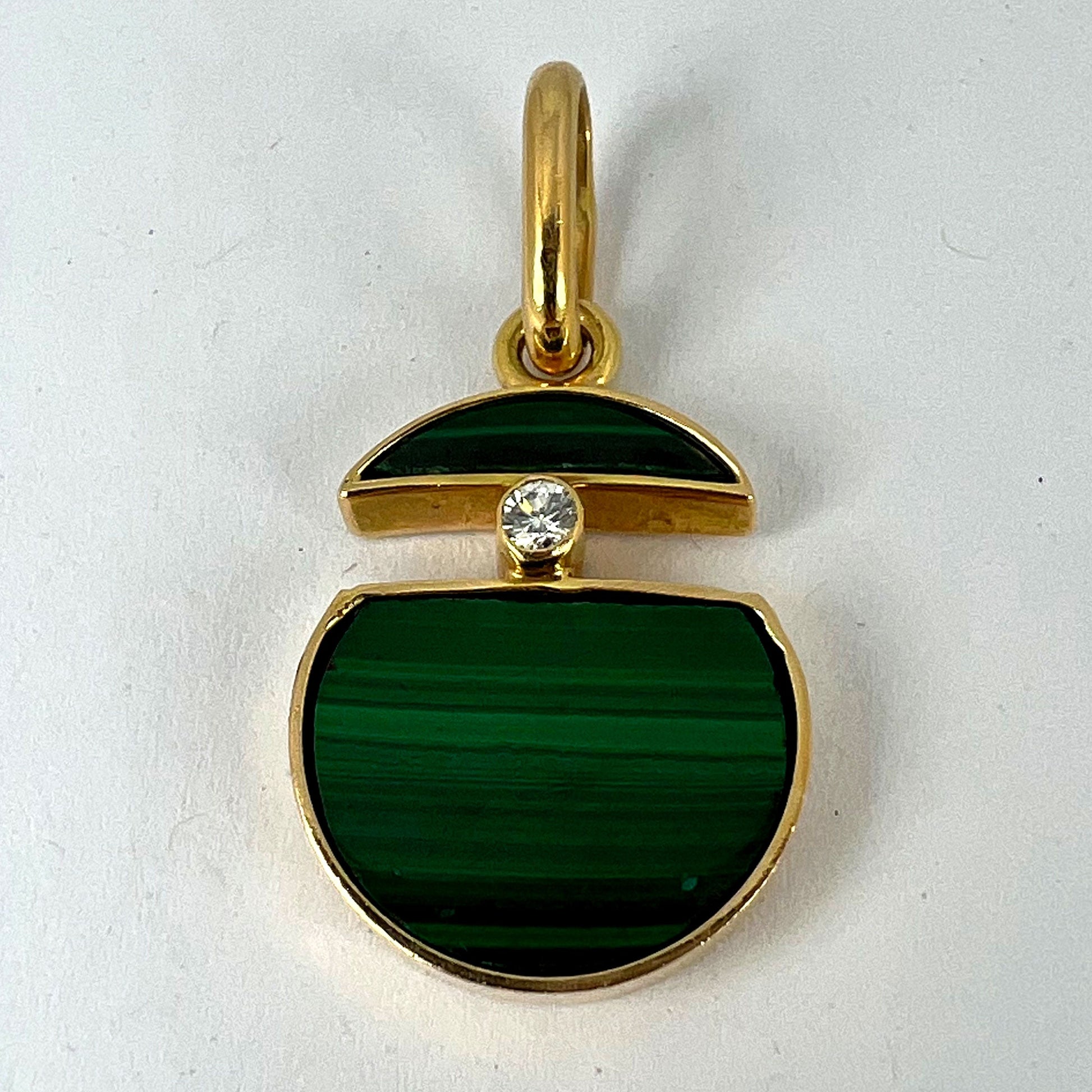 A malachite and diamond yellow gold split circle pendant, on a white background