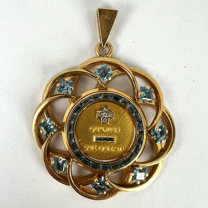 A yellow gold French QU'HIER QUE DEMAIN pendant with blue stones and diamonds, on a white background
