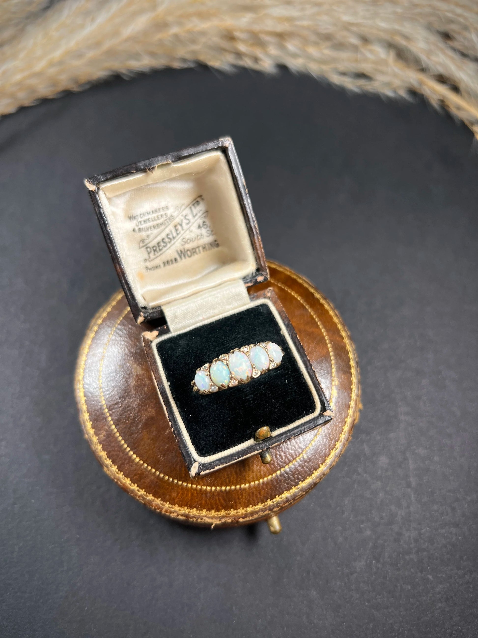 A cabochon opal and diamond carved half hoop ring in yellow gold, in a ring box