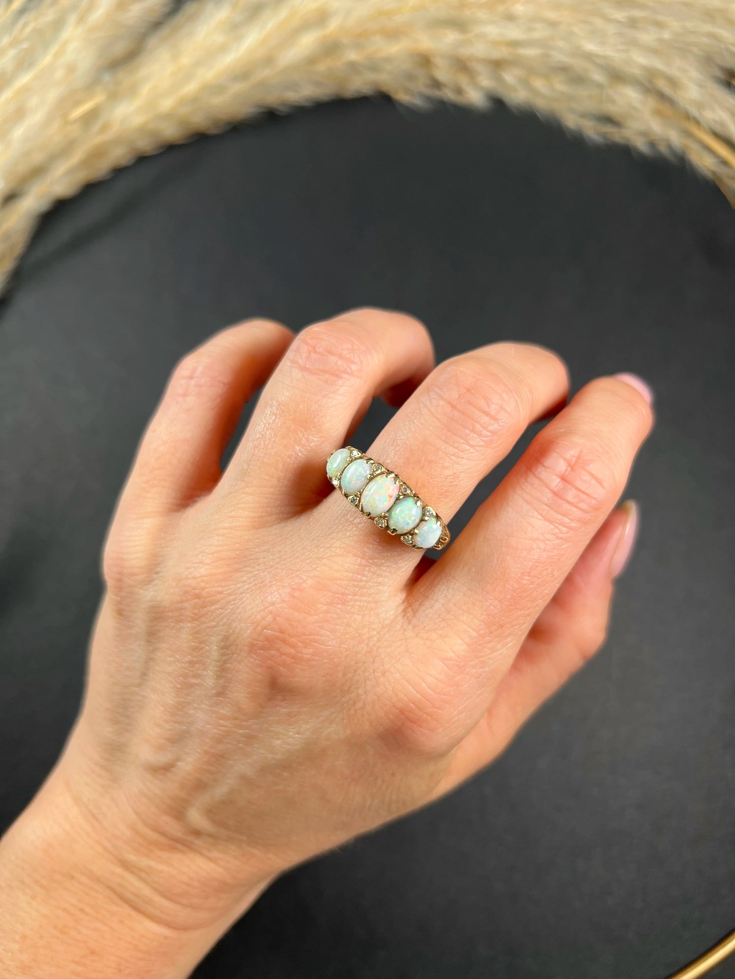 A cabochon opal and diamond carved half hoop ring in yellow gold, modelled on a hand