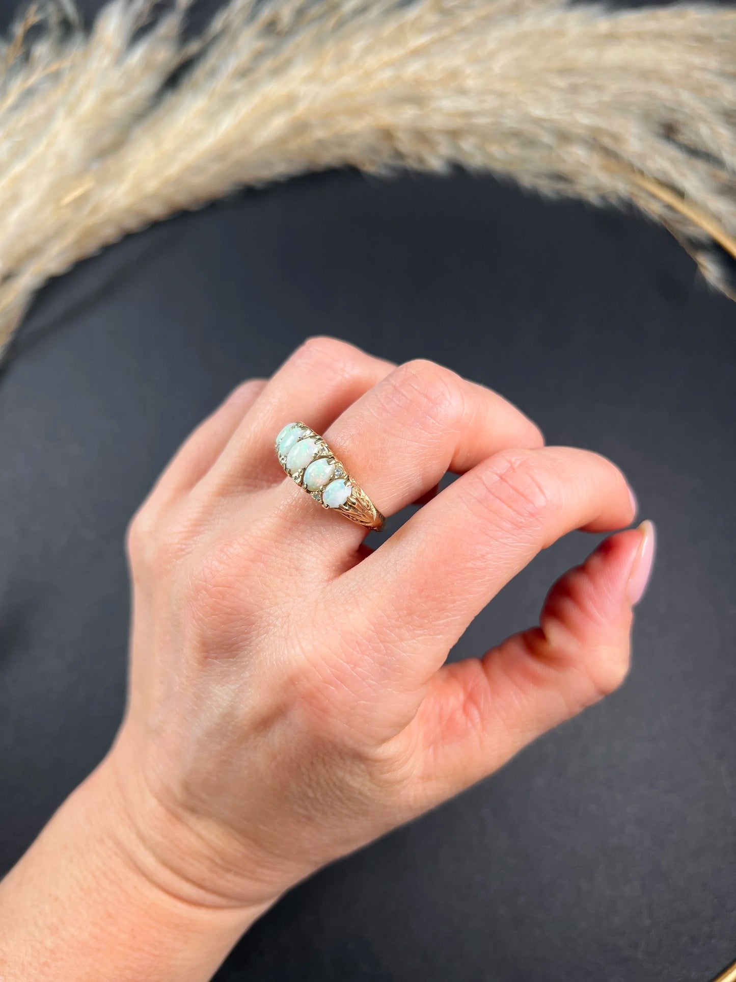 A cabochon opal and diamond carved half hoop ring in yellow gold, modelled on a hand