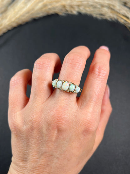 A cabochon opal and diamond carved half hoop ring in yellow gold, modelled on a hand