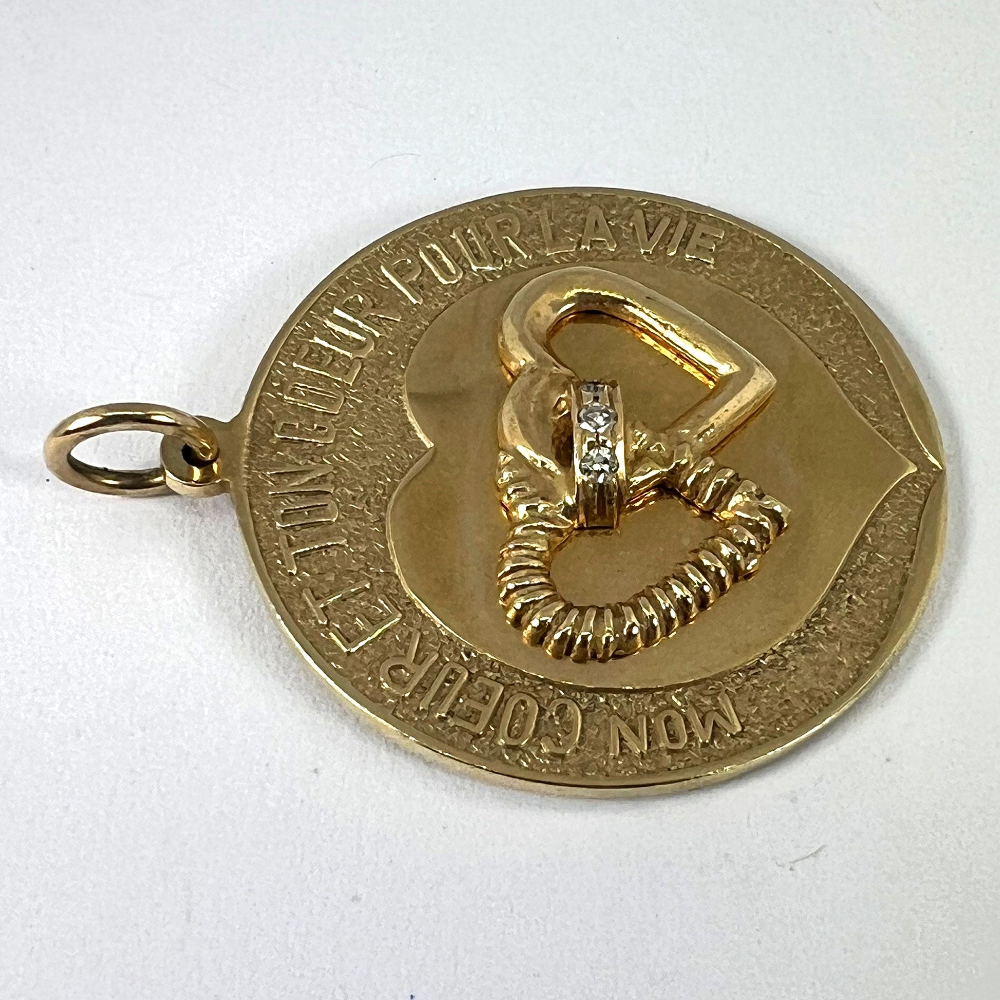 A round yellow gold love heart diamond pendant engraved MON COEUR ET TON COEUR POUR LA VIE