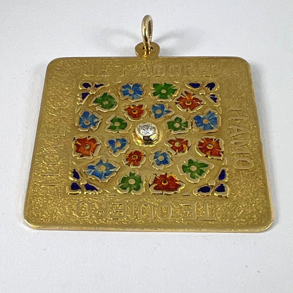 A square shaped yellow gold pendant with enamelled flowers and a central diamond, with text reading JE T'ADORE, TI AMO, TE QUIERO, I LOVE YOU