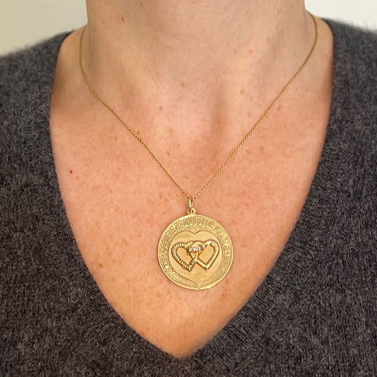 A round yellow gold love heart diamond pendant engraved MON COEUR ET TON COEUR POUR LA VIE, modelled on a gold chain