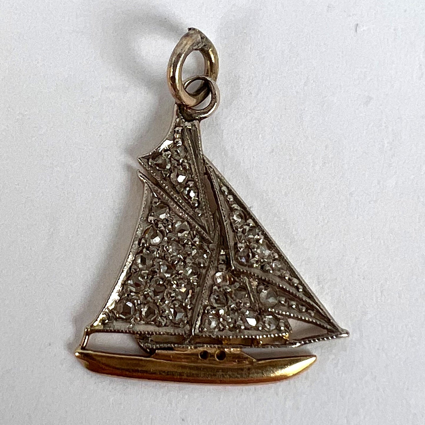 A diamond set yacht boat pendant, on a white background