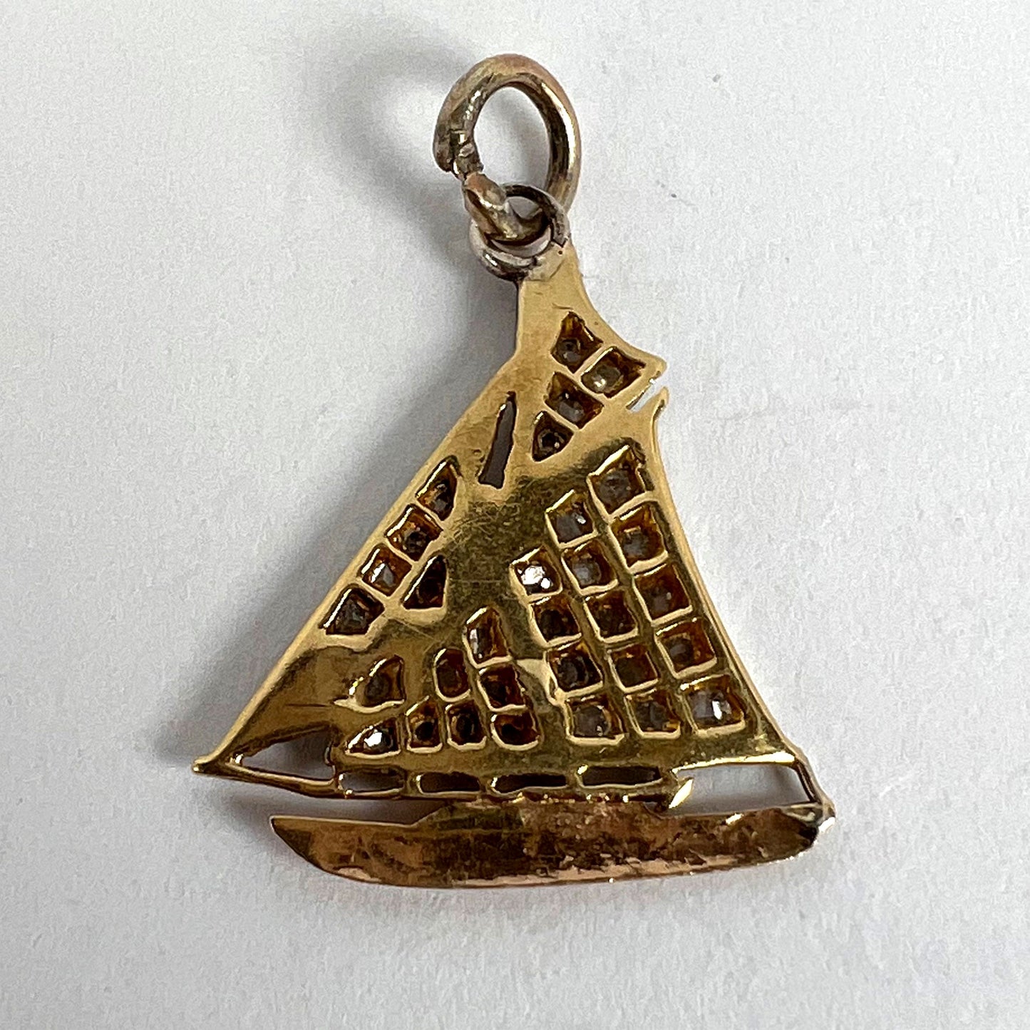 A diamond set yacht boat pendant, on a white background