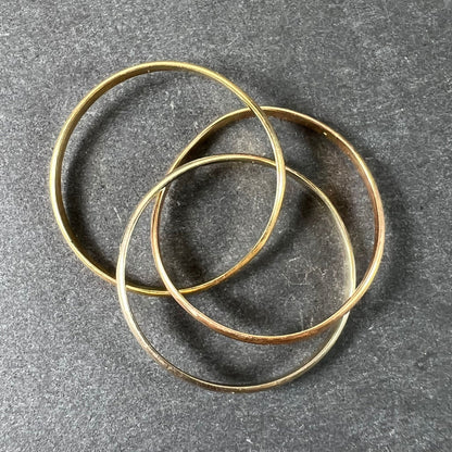 A tri-colour gold Russian wedding ring, on a grey background