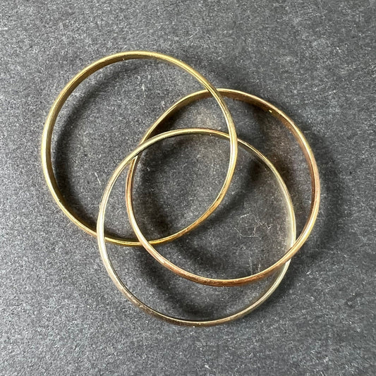 A tri-colour gold Russian wedding ring, on a grey background