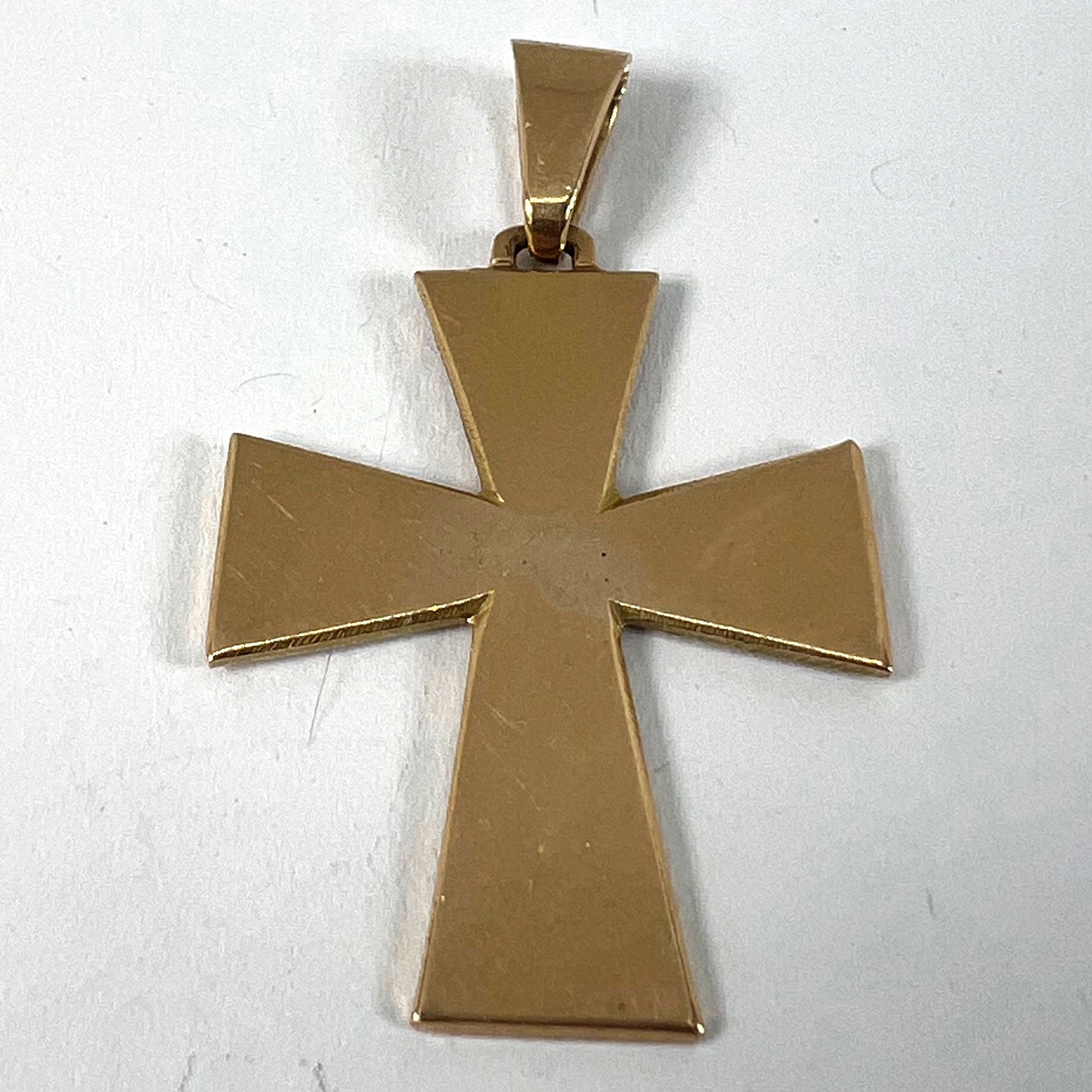 A plain gold cross pendant, on a white background
