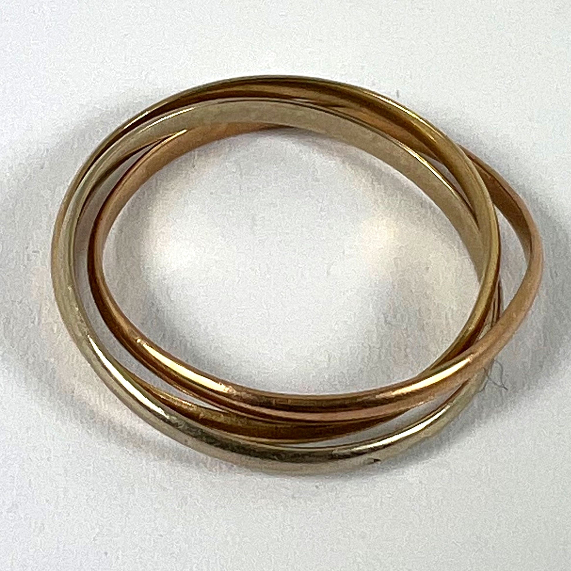 A tri-colour gold Russian wedding ring, on a white background