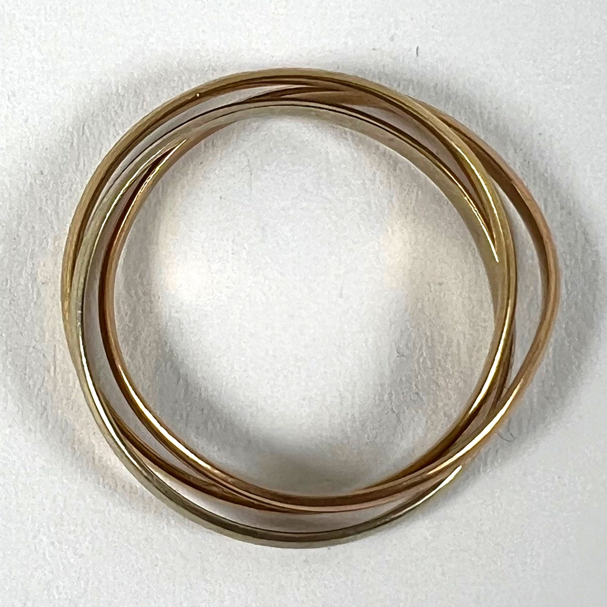A tri-colour gold Russian wedding ring, on a white background