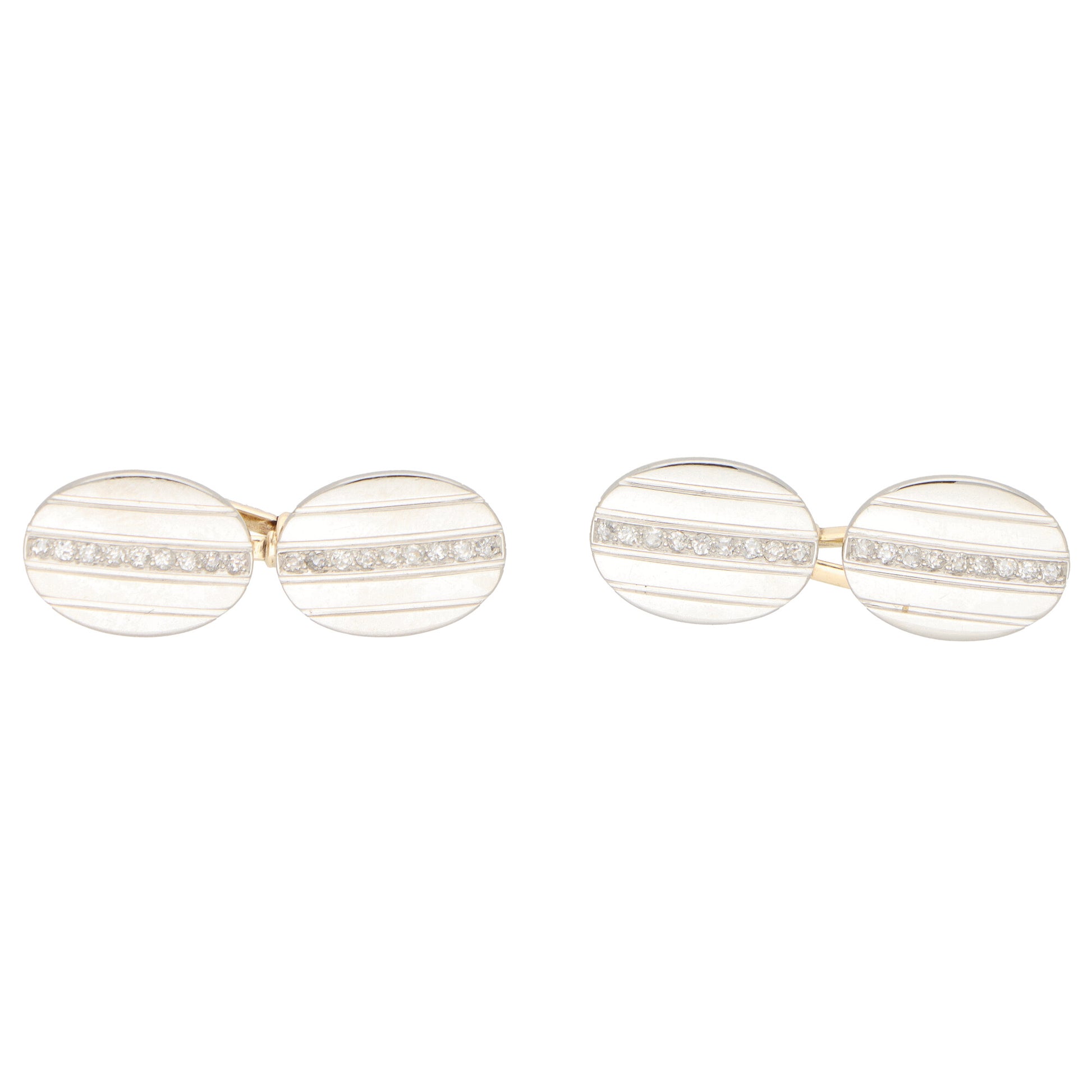 A pair of oval cufflinks in yellow and white metal set with diamonds, on a white background