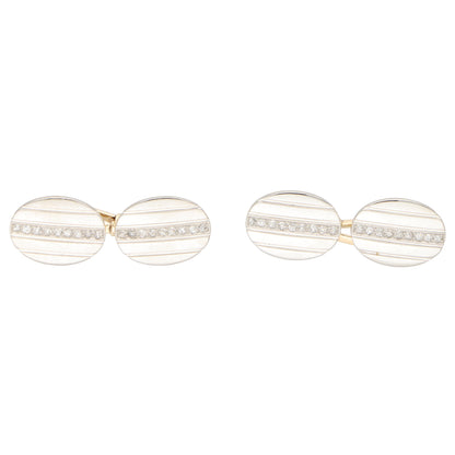 A pair of oval cufflinks in yellow and white metal set with diamonds, on a white background