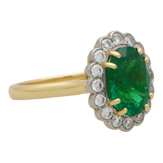 Emerald and diamond cluster ring in gold and platinum.