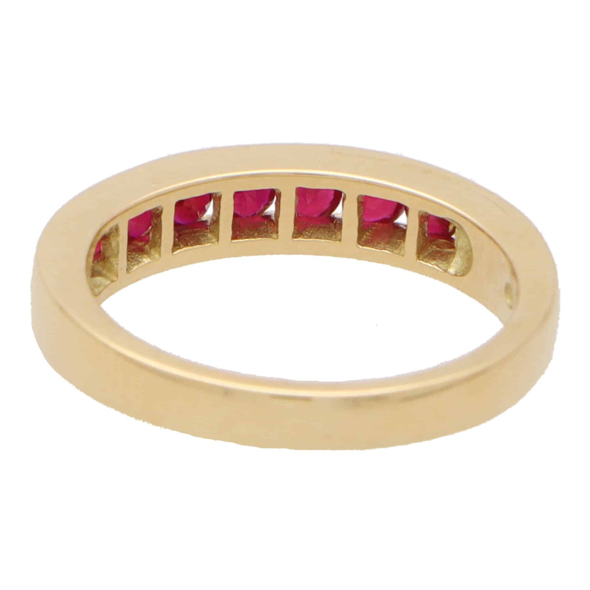 Ruby half eternity ring set in 18 carat yellow gold.