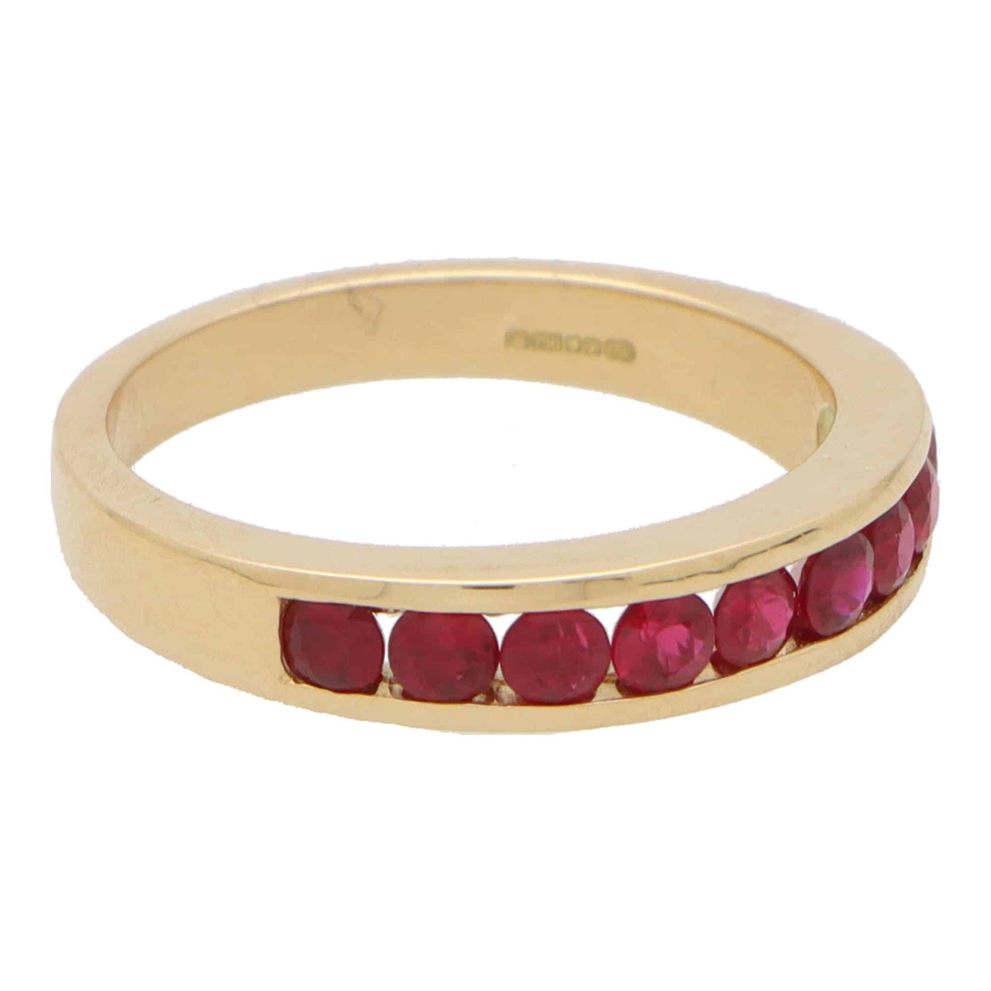 Ruby half eternity ring set in 18 carat yellow gold.