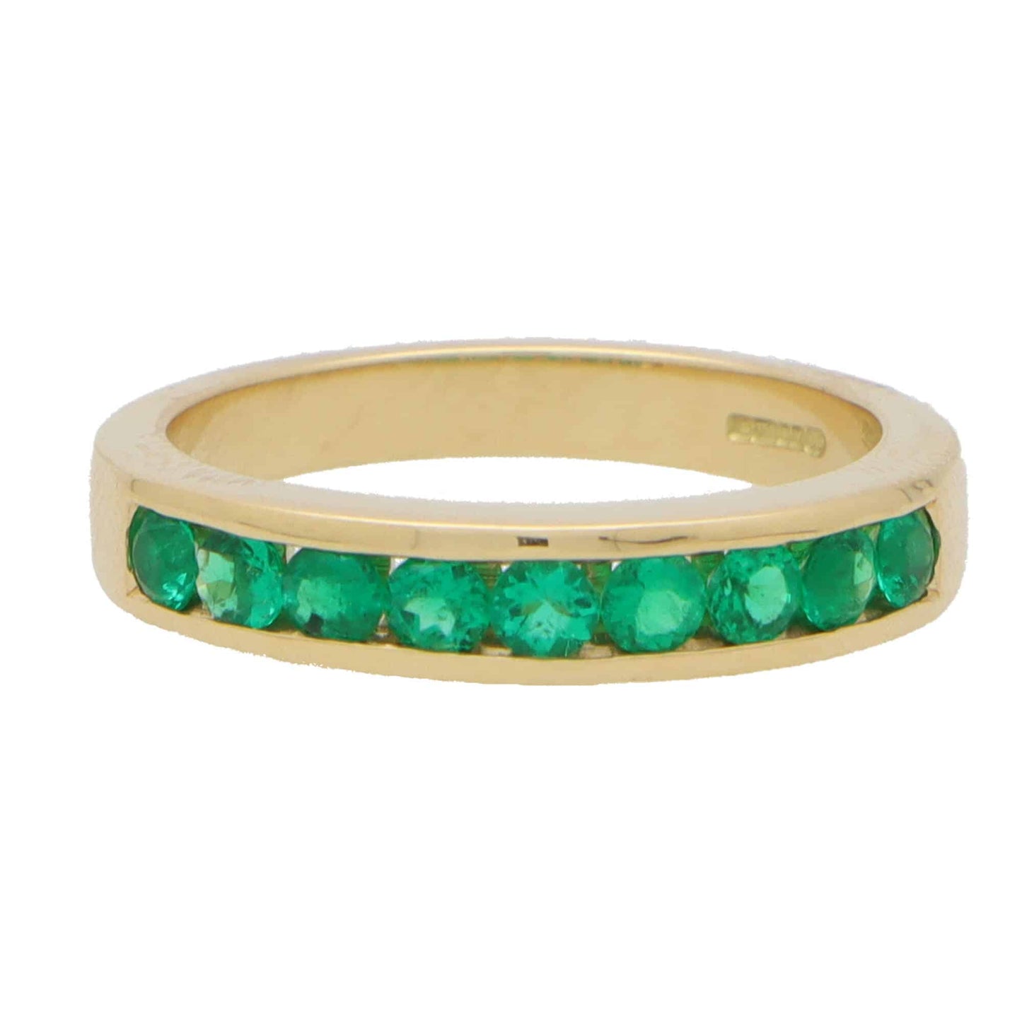 Emerald half eternity ring set in yellow gold.